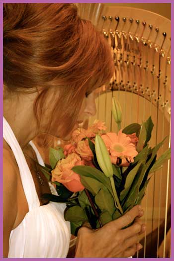 Bride holding bouquet in front of wedding harp